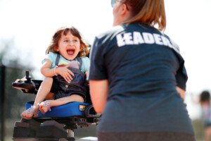 girl in wheelchair smiling while playing